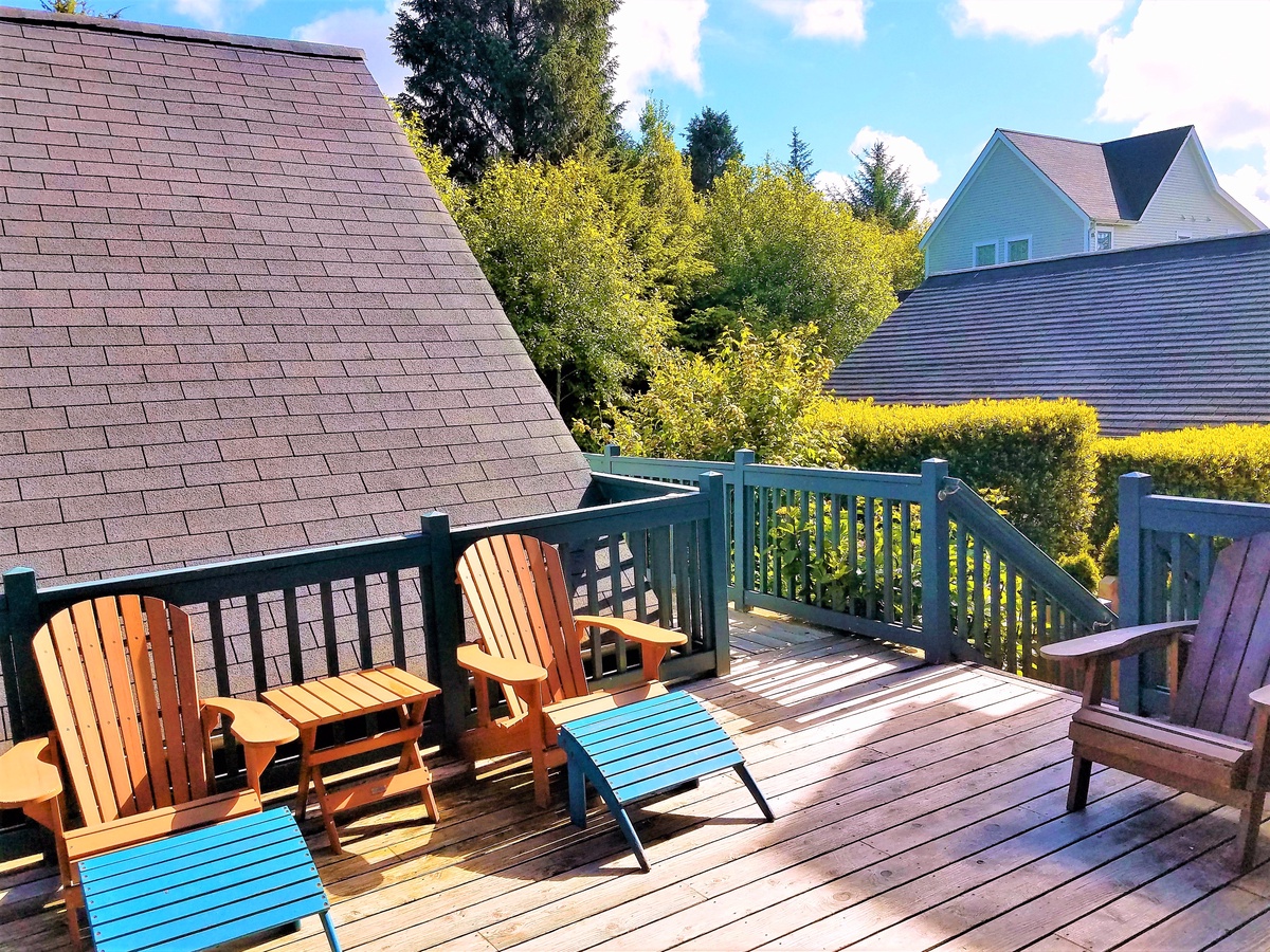 Private sunny backyard deck with lounge chairs, gas BBQ and lovely forest views