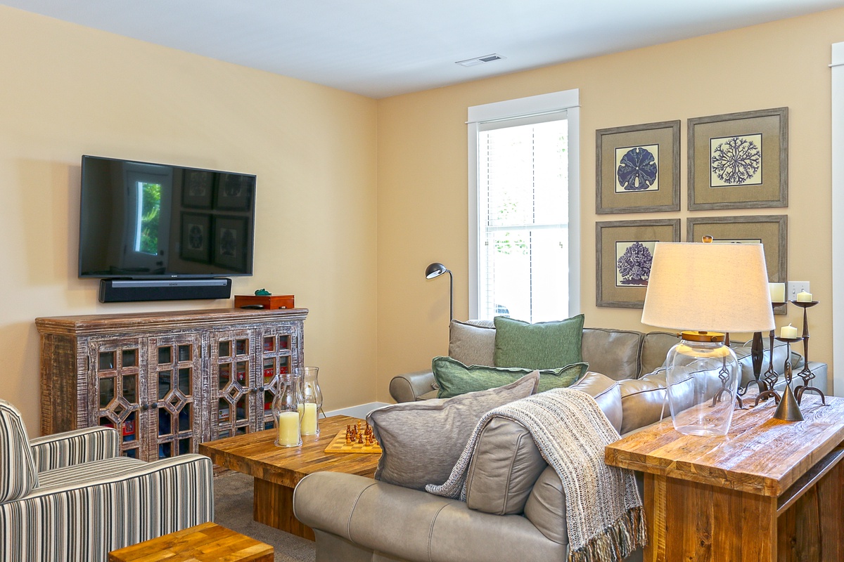 Lower level media room with large sofa and flat screen tv for movie night