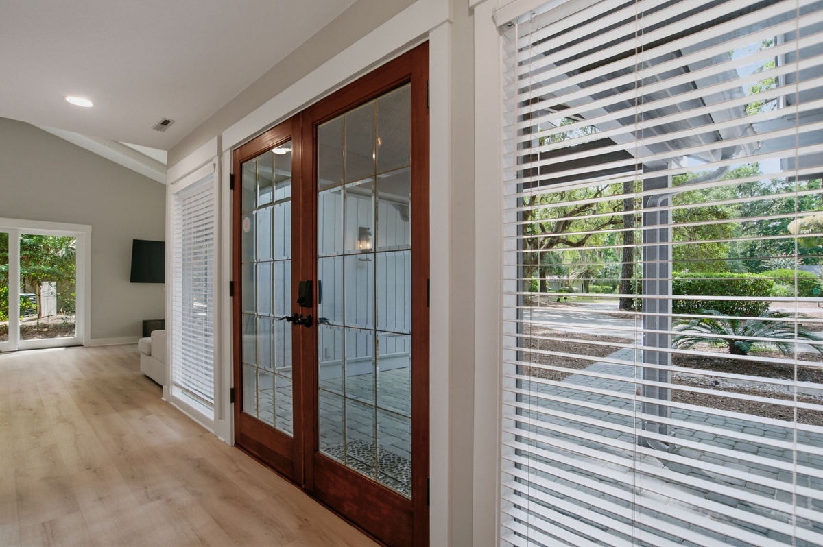 Step through elegant glass doors into your bright, modern retreat where natural light fills every corner and peaceful garden views greet you at every turn.