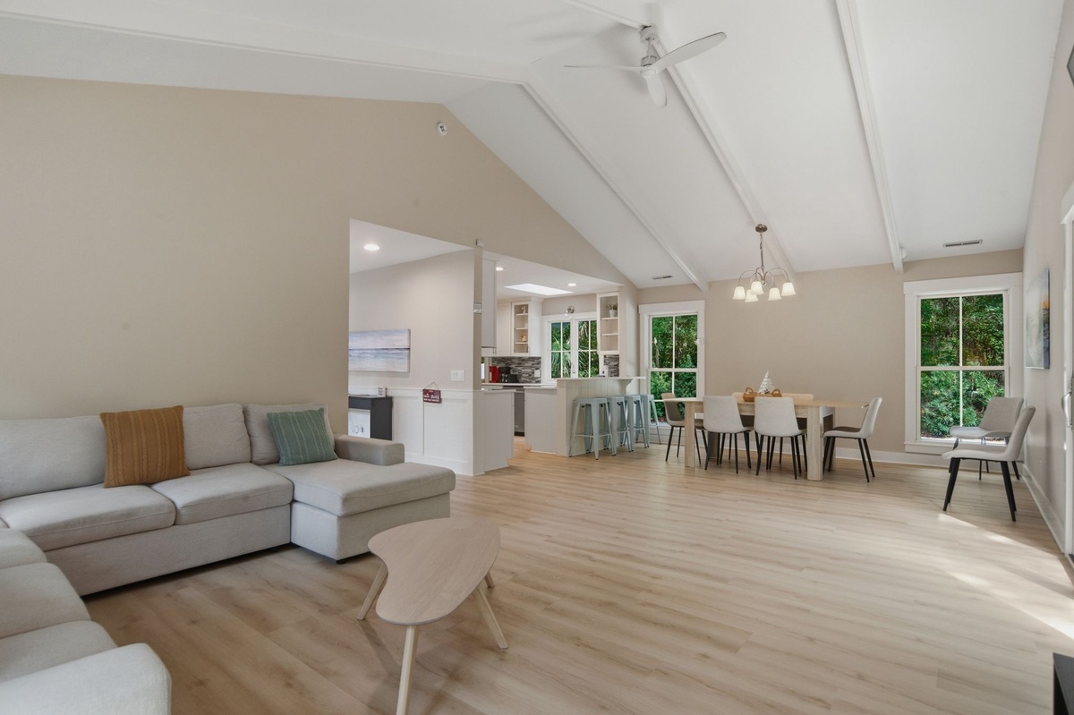 Light pours through tall windows into your open-concept living and dining area, where vaulted ceilings and modern finishes create an airy, welcoming retreat perfect for gathering with loved ones.