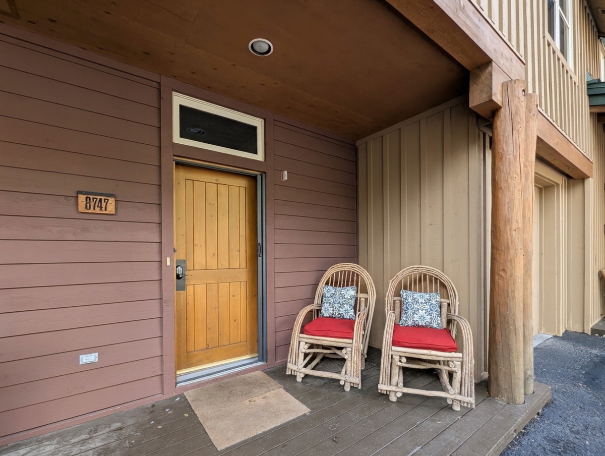 The welcoming front entrance features a charming covered porch with seating, perfect for your morning coffee or evening relaxation.