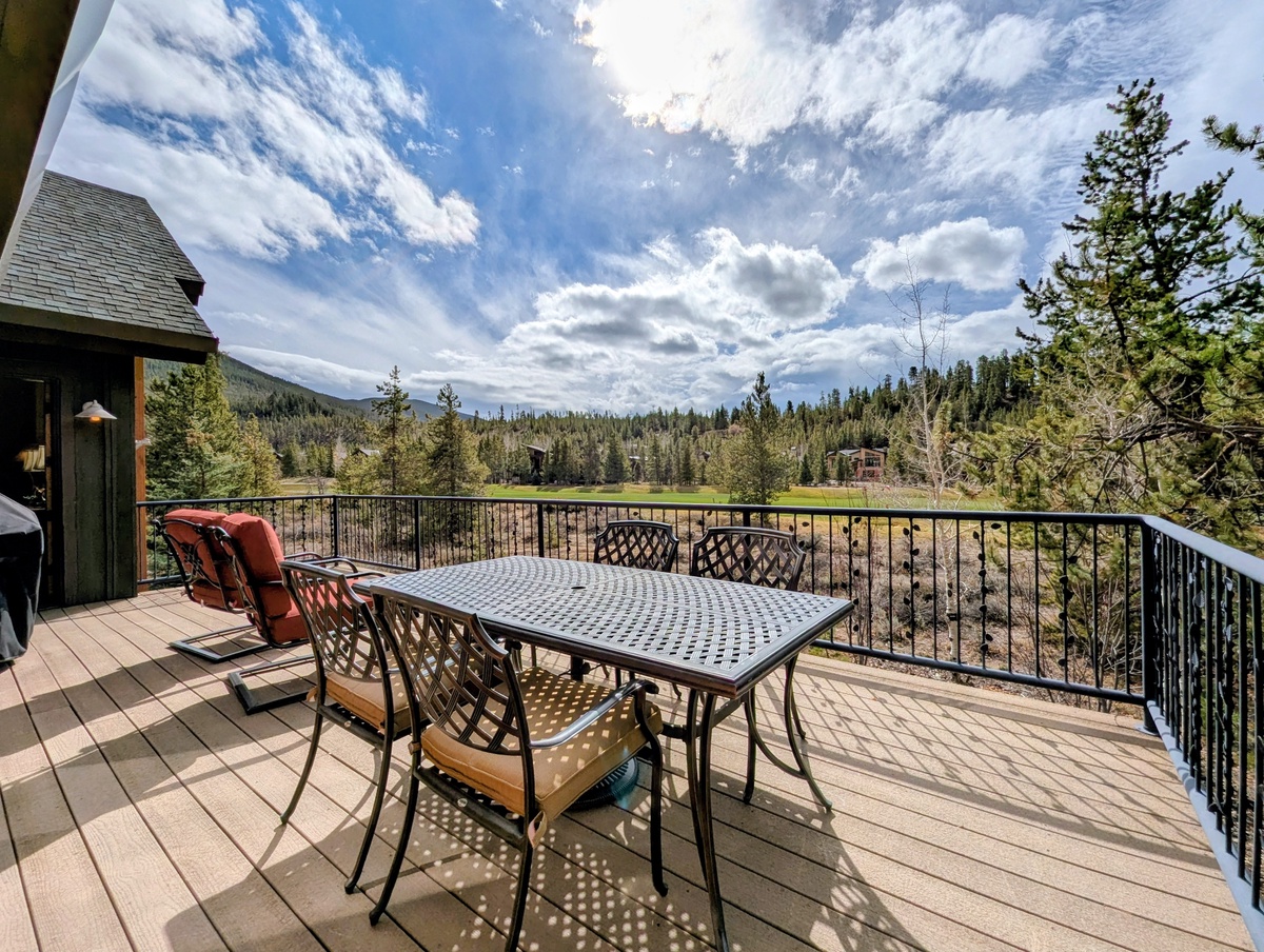 A spacious deck where you can dine under sweeping skies, surrounded by evergreens and mountain views, perfect for peaceful mornings or relaxed evening meals.