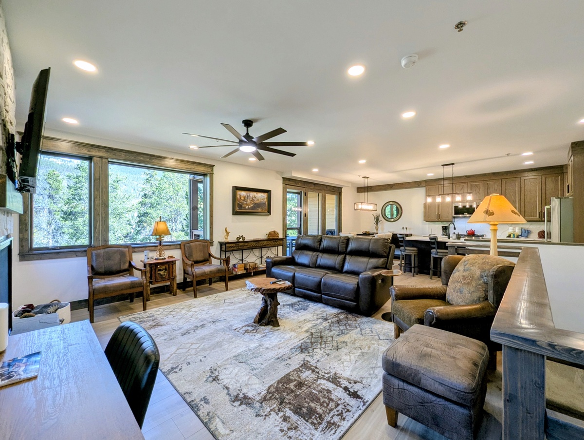 Sink into plush seating and let the natural light from floor-to-ceiling windows brighten your stay in this spacious open-concept living area where cozy comfort meets modern style.