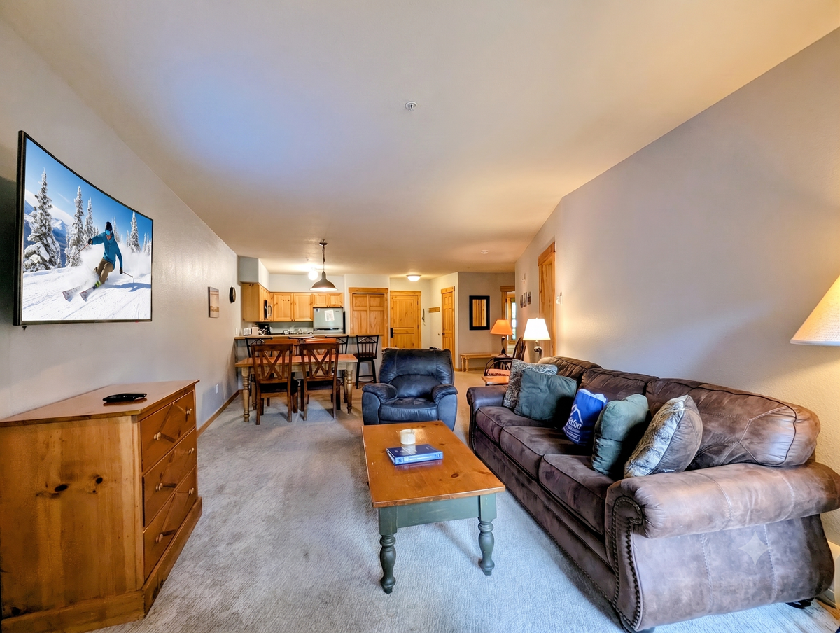 Your spacious mountain condo welcomes you with warm lighting and comfortable leather seating, flowing seamlessly into a fully equipped kitchen and dining area where your group can gather after a day exploring the slopes.