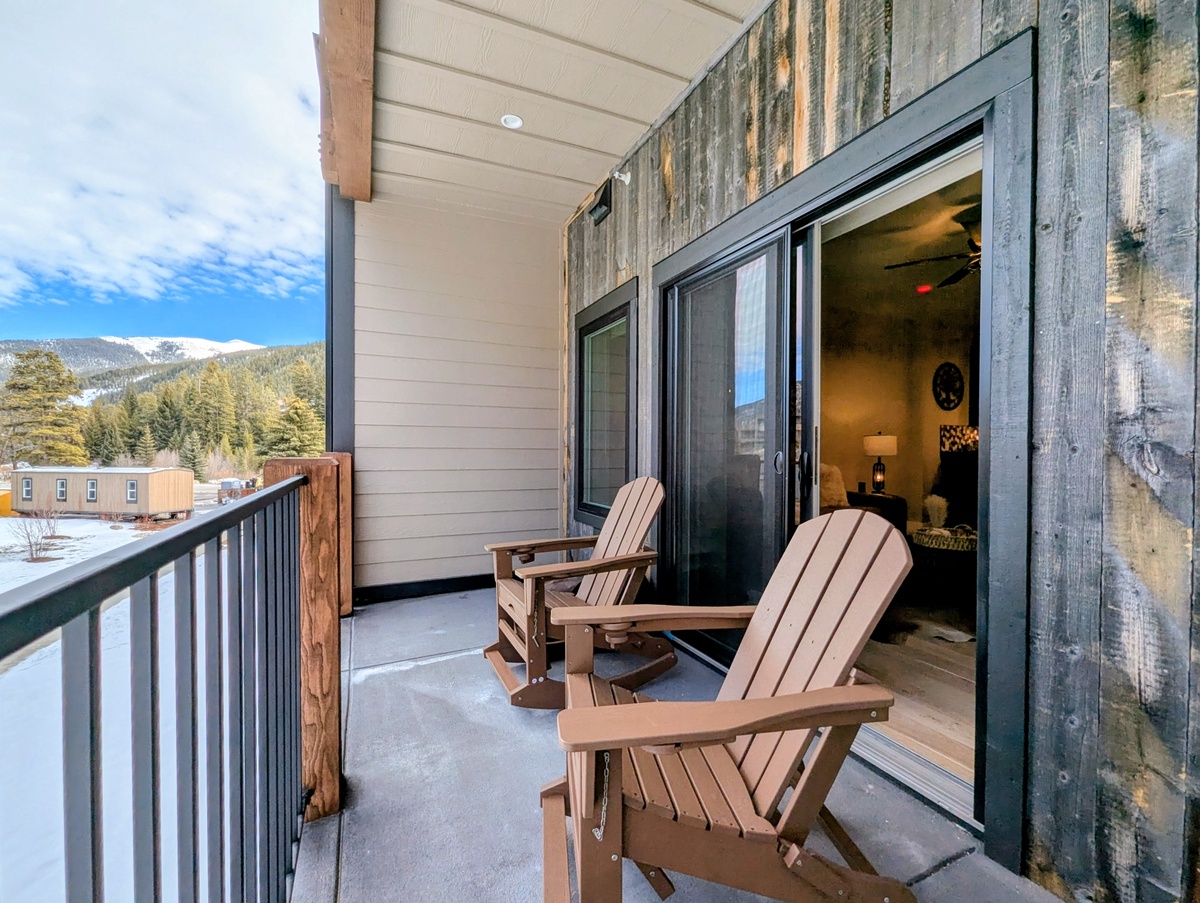 Unwind on your private balcony with mountain views, enjoying coffee in comfortable Adirondack chairs while taking in the peaceful winter scenery.