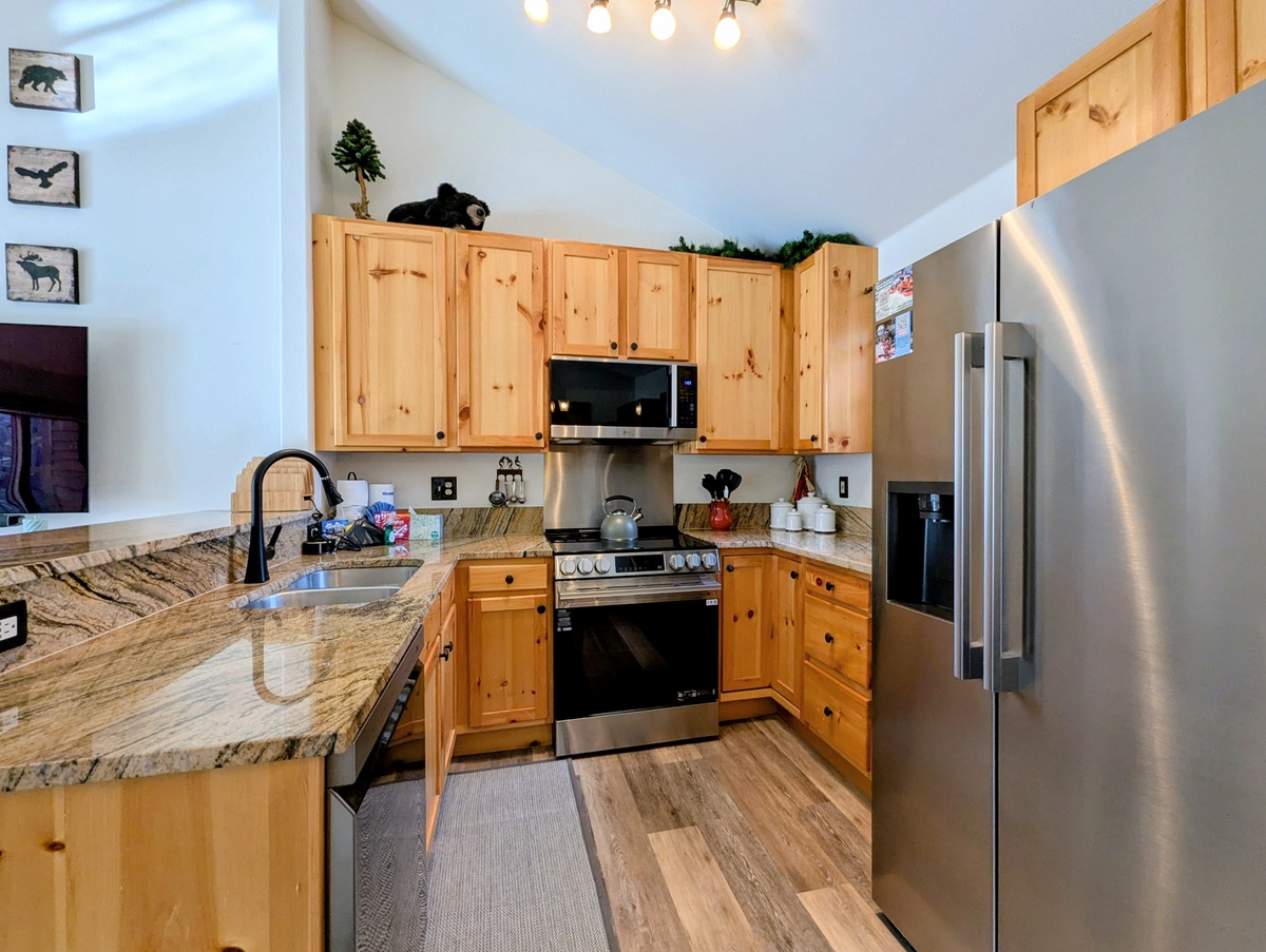 Your fully equipped kitchen features beautiful stone countertops, stainless steel appliances, and cozy rustic charm for preparing meals together.