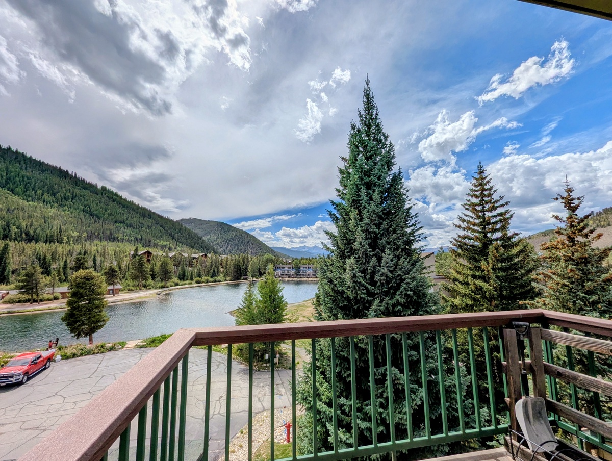 Step out onto your private balcony and take in sweeping views of a tranquil lake framed by towering pines and majestic mountain peaks under an endless blue sky.