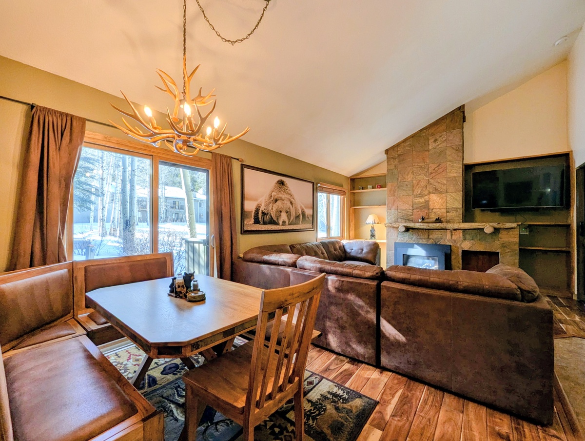 Cozy up by your stone fireplace in this rustic living room, where plush leather seating and wildlife art create the perfect mountain retreat atmosphere.