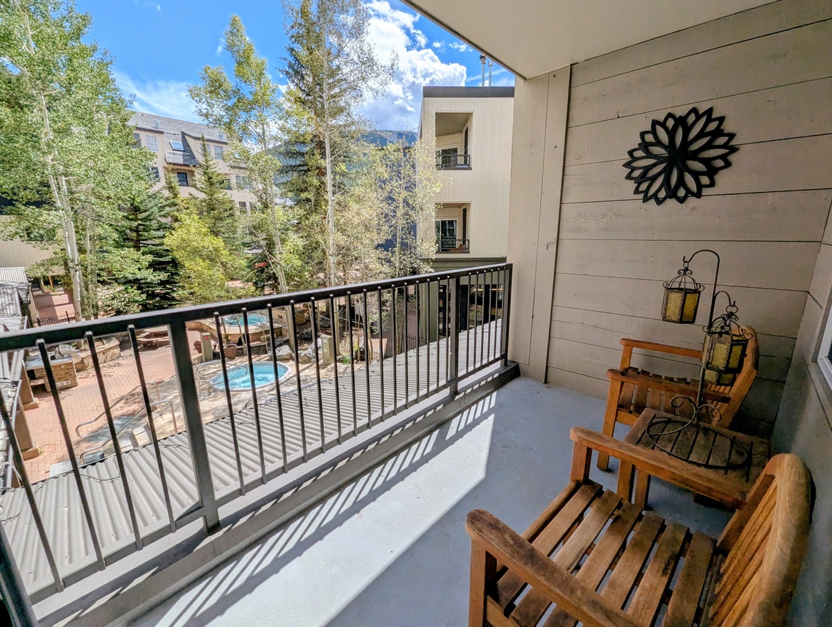 Step out onto your private balcony and take in the surrounding mountain scenery. Relax in the wooden chairs, enjoy the fresh air, and catch glimpses of the pool below through the trees.