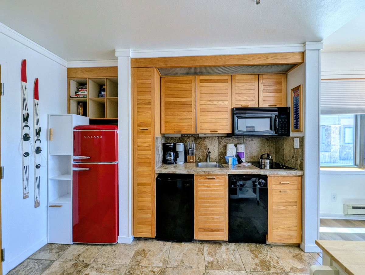 Your fully equipped kitchenette makes meal prep a breeze, with charming wood cabinetry, modern appliances, and granite countertops creating a warm, functional space for your culinary adventures.