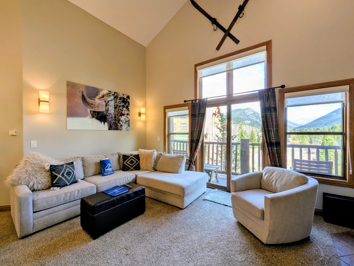 Sink into plush seating while soaking up stunning mountain vistas through expansive windows in your bright, beautifully appointed living space.