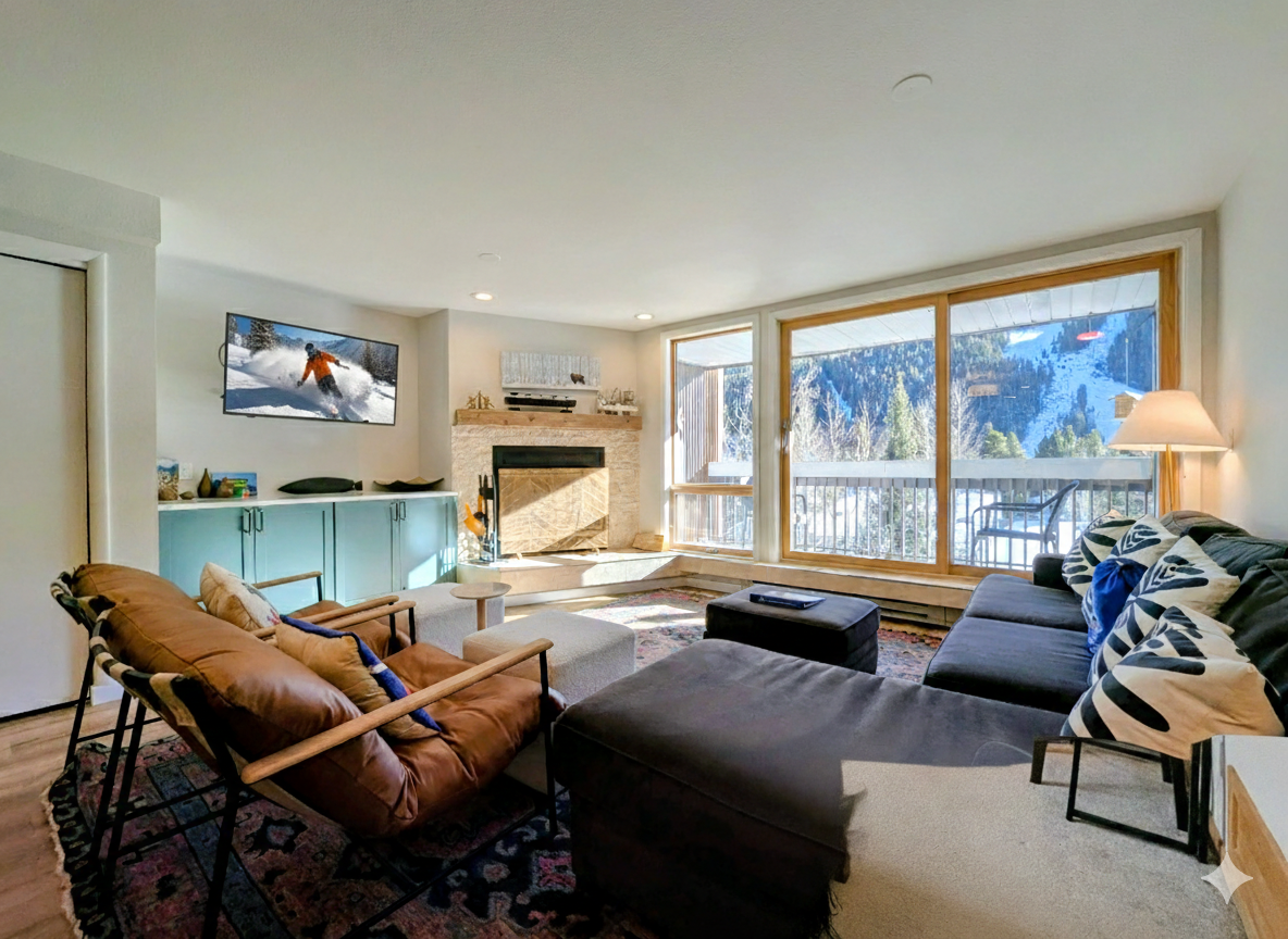 Unwind in your spacious living room with cozy seating, a crackling fireplace, and stunning mountain views through expansive windows.