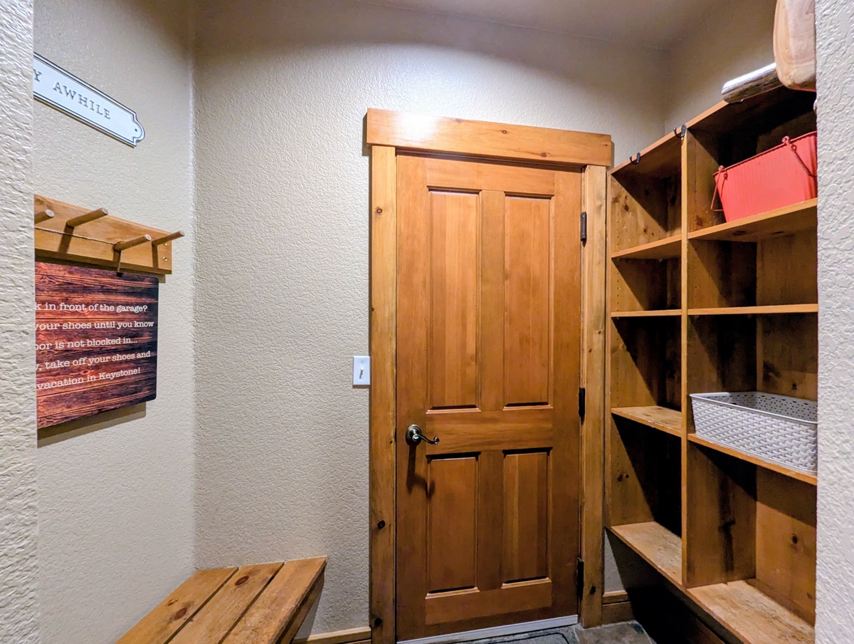 Your private entrance awaits, with rustic wooden storage cubbies ready to hold your gear and a welcoming bench for pulling off ski boots after a day on the slopes.
