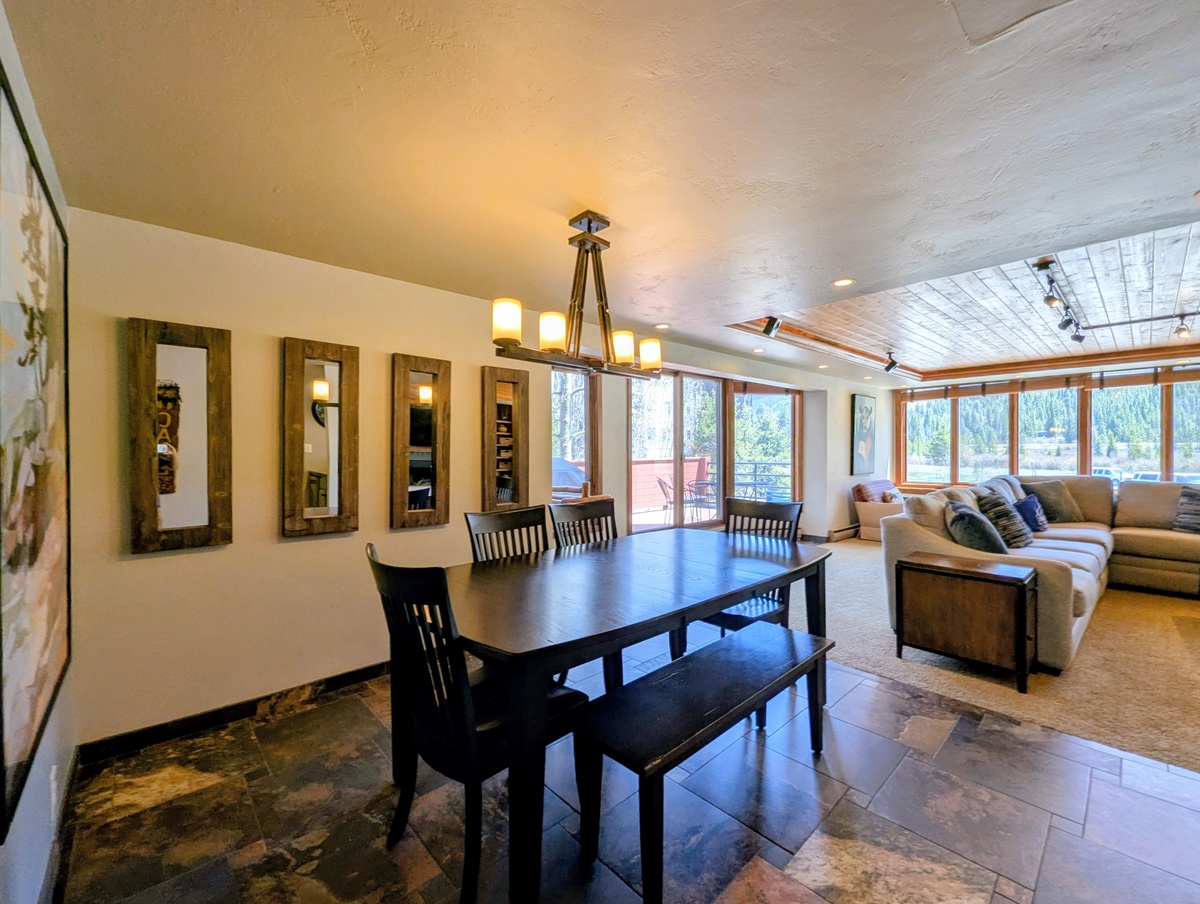 Gather around your spacious dining table while soaking in serene lake views through expansive windows. The open layout flows seamlessly to your cozy living area, perfect for relaxing evenings together.