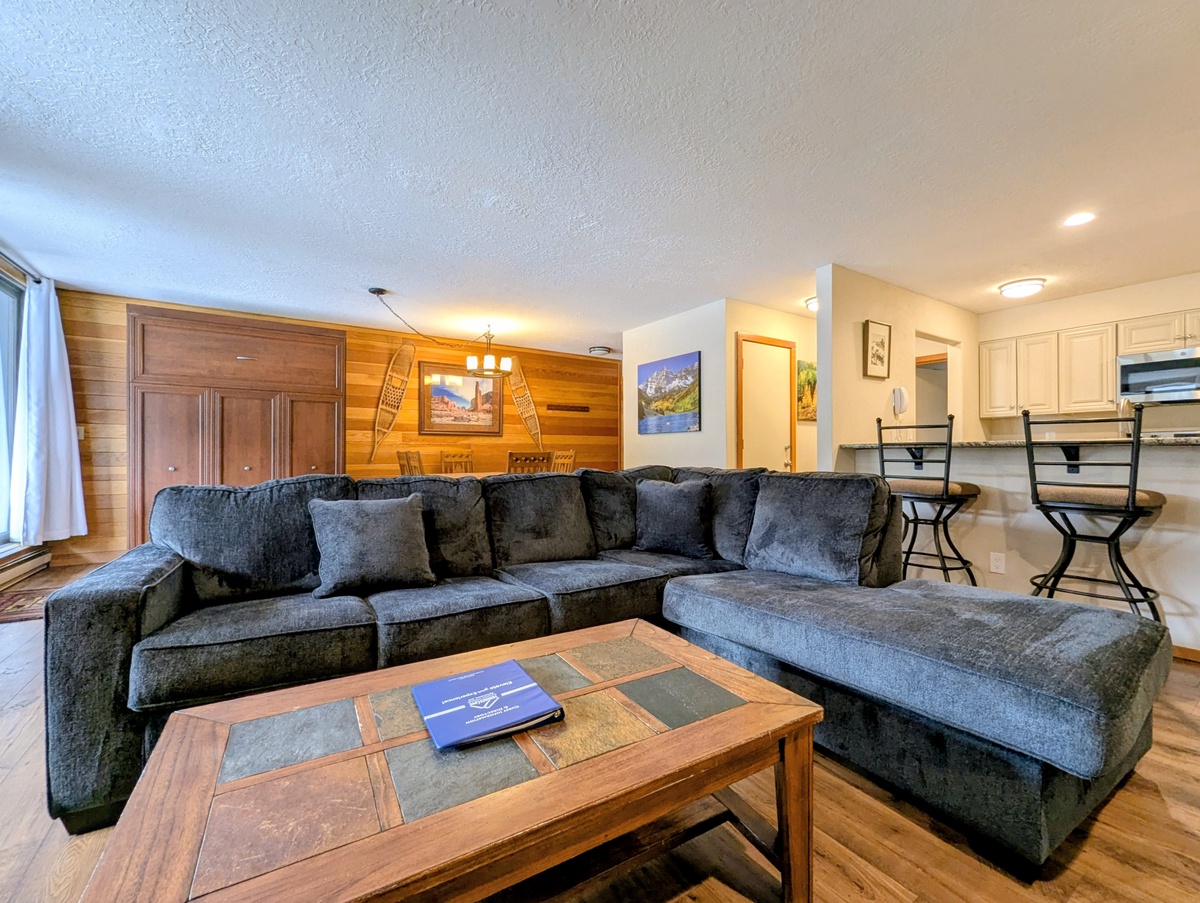 Sink into the plush sectional sofa and unwind in your spacious living area, where warm wood accents create a cozy mountain retreat.