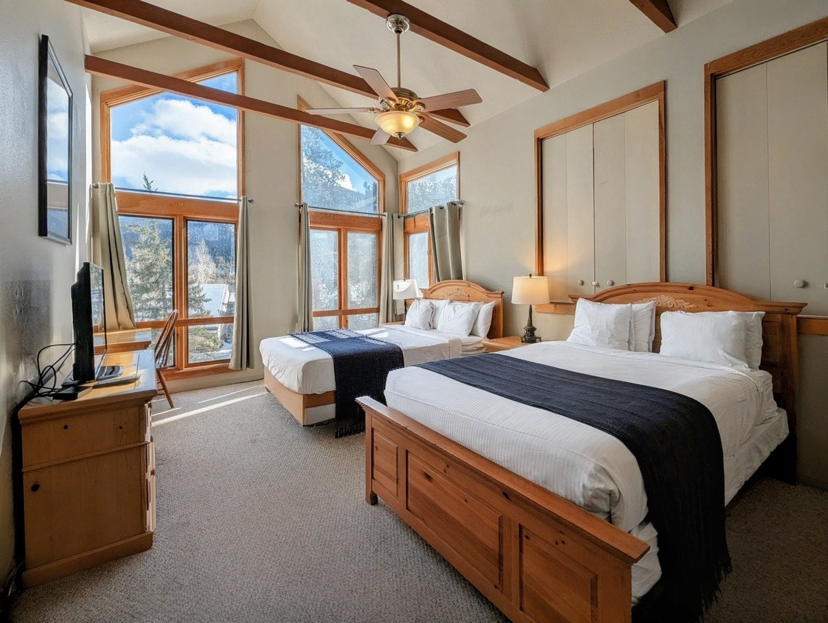 Cozy up in your mountain retreat with rustic wood beams overhead and panoramic windows framing snowy peaks. Two comfortable beds await after your alpine adventures.