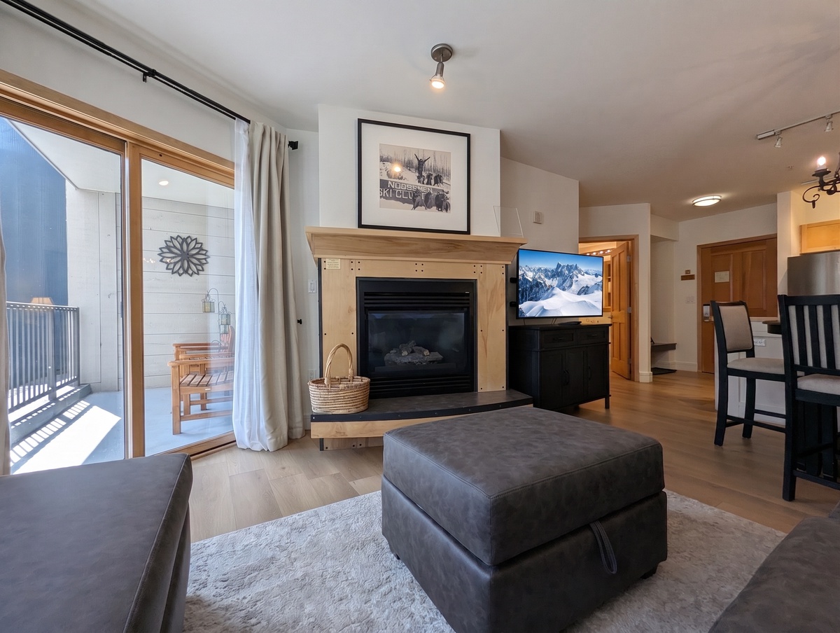 Settle into your cozy living room where a warm fireplace and natural light create the perfect retreat after your mountain adventures.