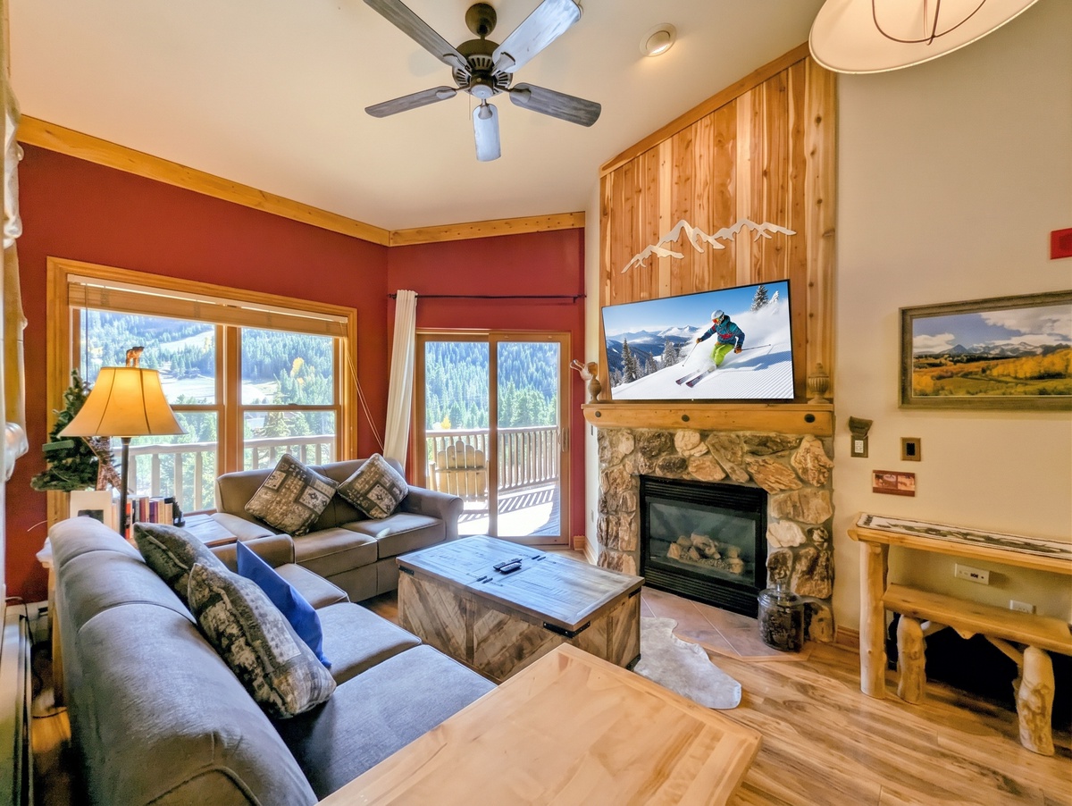 Unwind in your cozy alpine retreat, where plush seating, a warm fireplace, and mountain views create the perfect après-ski haven.