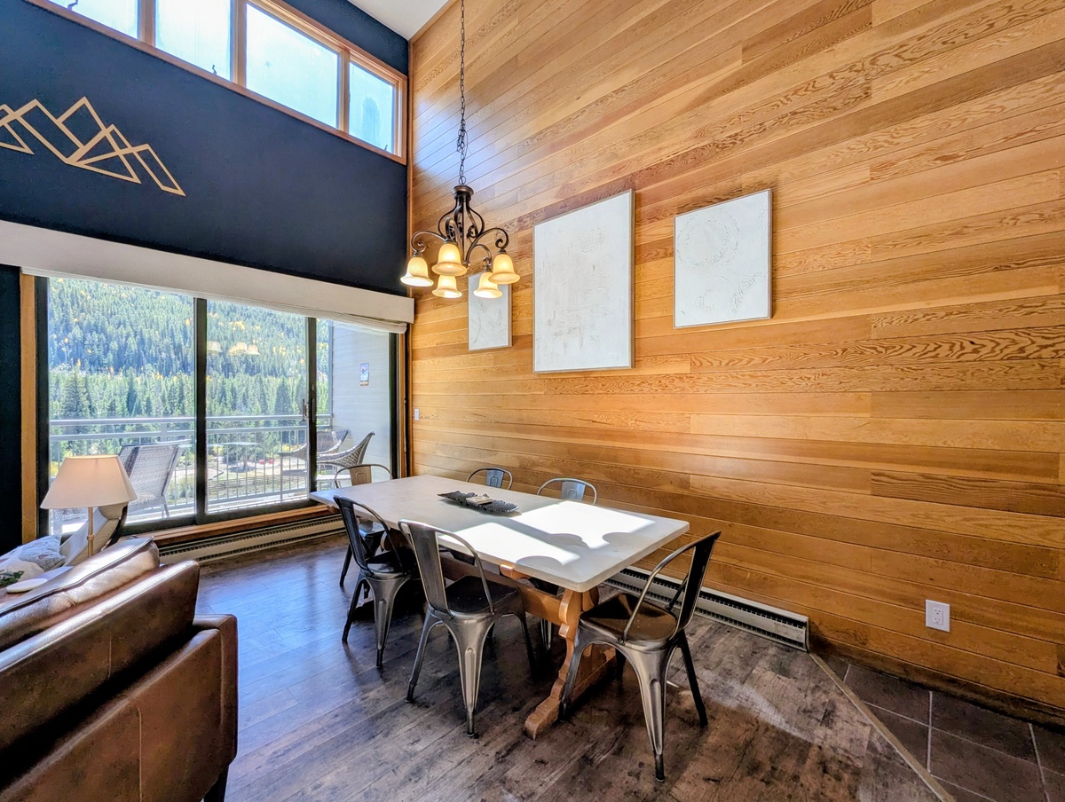 Step into your bright, modern mountain retreat, where soaring wood-paneled ceilings and an elegant dining space await. Your private balcony opens to stunning forest views.