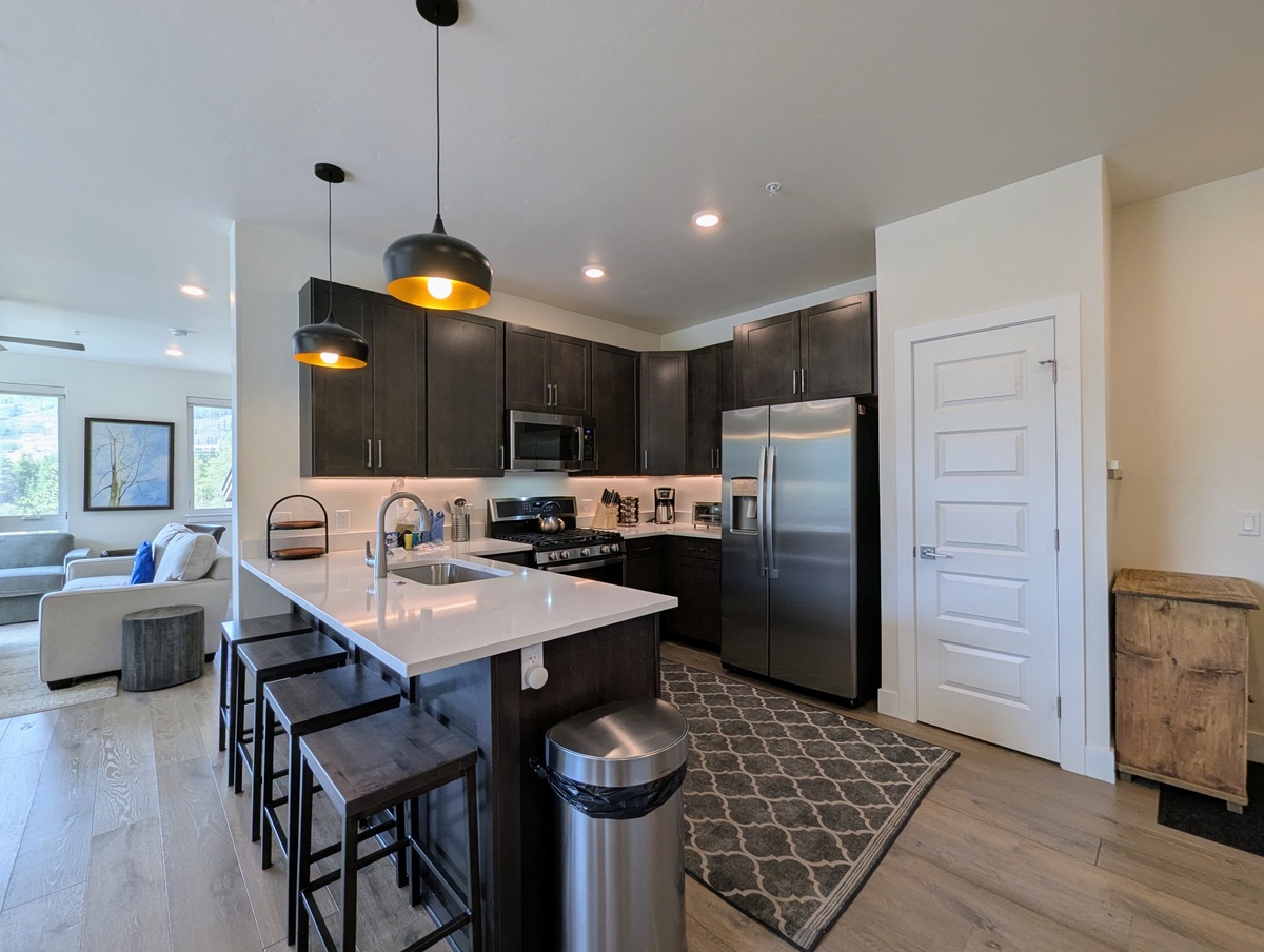 Your fully-equipped kitchen awaits with sleek modern appliances, a spacious island for meal prep and casual dining, and stylish lighting to brighten your mornings.