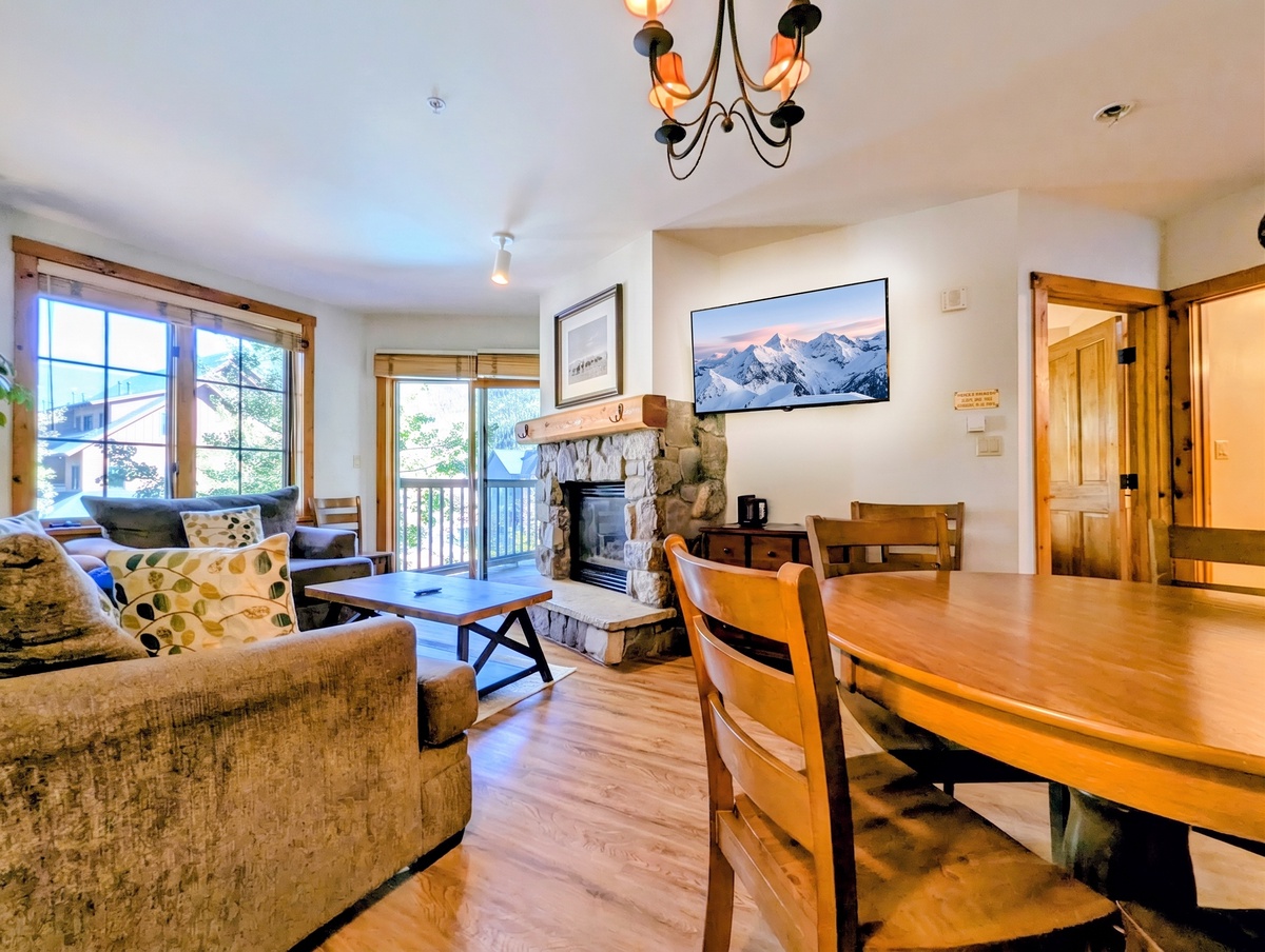 Step into your mountain retreat where a welcoming living space flows seamlessly into a cozy dining area. Warm wood accents, a charming fireplace, and abundant natural light create the perfect setting for relaxation after your adventures.