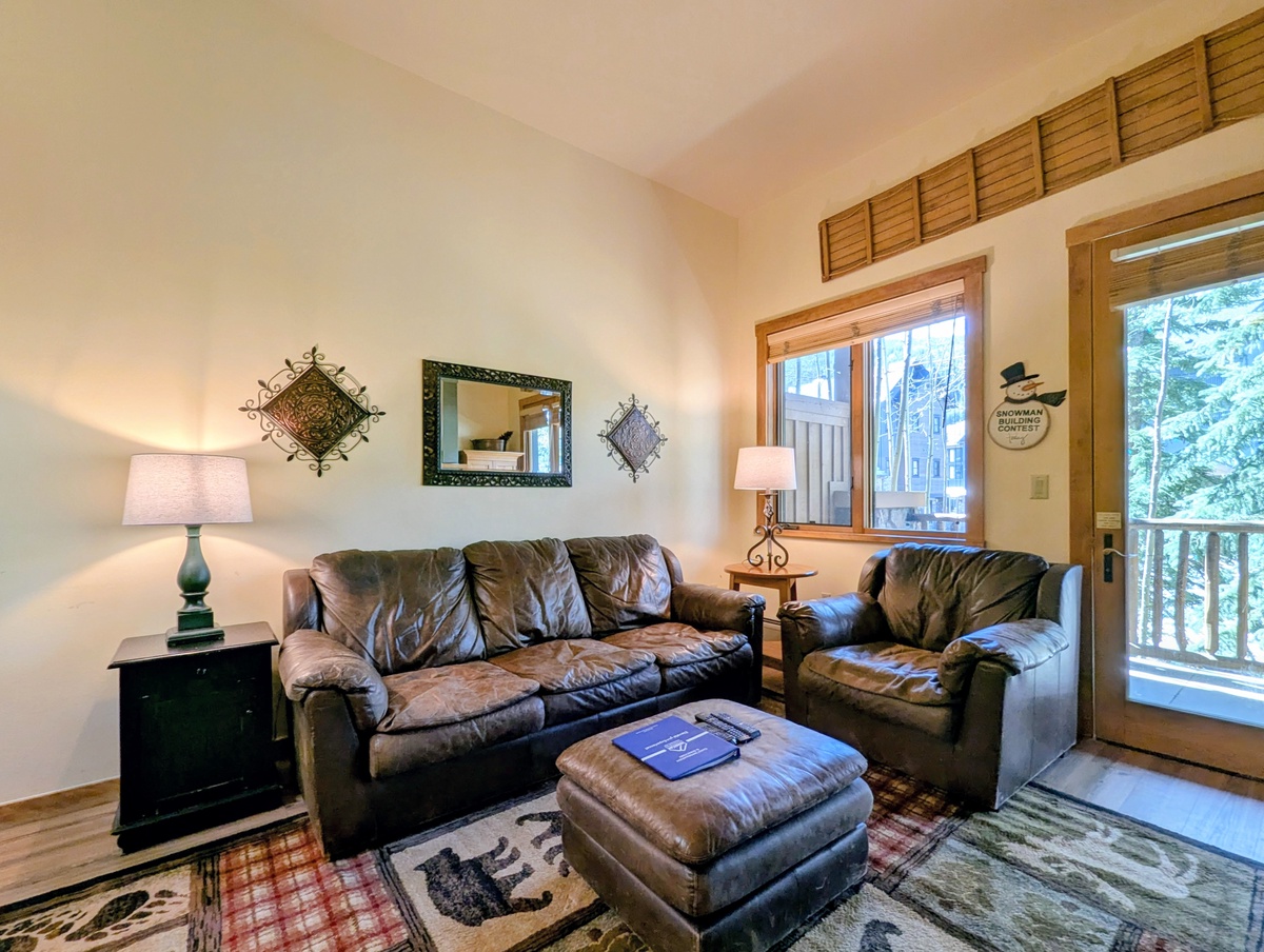 Sink into plush leather seating in your cozy living room, where natural wood accents and warm lighting create the perfect space to unwind after your mountain adventures.