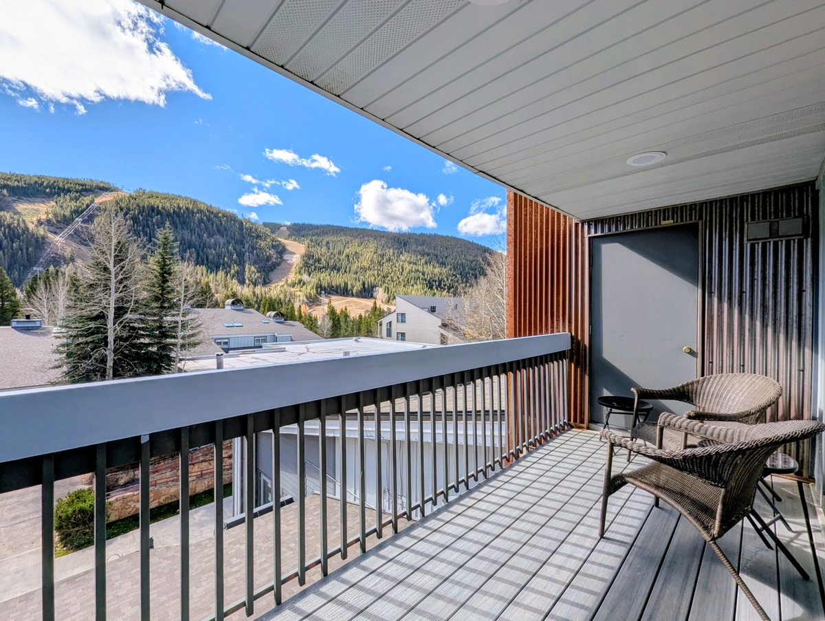 Spectacular mountain vistas frame this property, nestled in a picturesque alpine setting with forested peaks and crisp blue skies overhead.