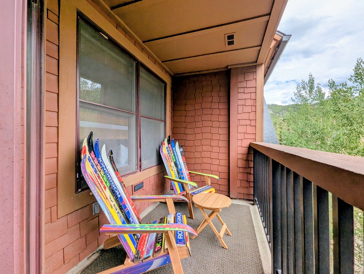 Relax on your private balcony with mountain views and colorful seating that brings a playful alpine vibe to your outdoor retreat.