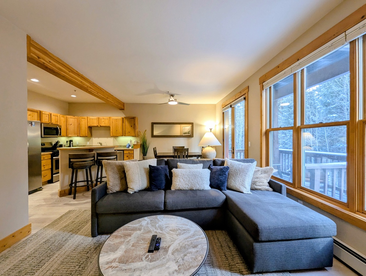 Sink into your spacious sectional sofa and enjoy forest views through large windows in this open-concept retreat.