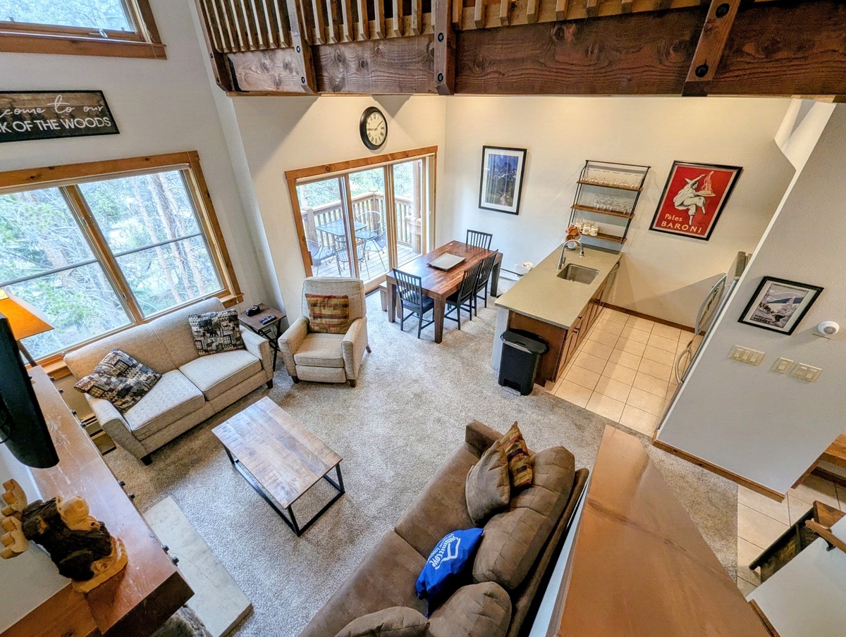 Your inviting retreat features soaring wood-beam ceilings and abundant natural light that floods through oversized windows. Sink into comfortable seating while enjoying treetop views from this spacious, open-concept living area with a full kitchen.