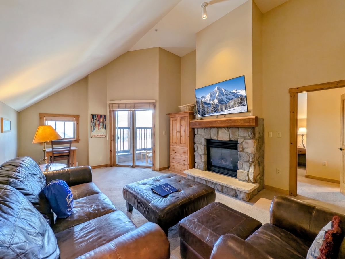 Unwind in your spacious living room, where vaulted ceilings and a stone fireplace create a warm mountain retreat. Step out onto your private balcony and soak in the views.
