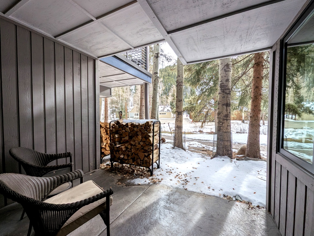 Cozy enclosed patio with comfortable seating and ski slope views