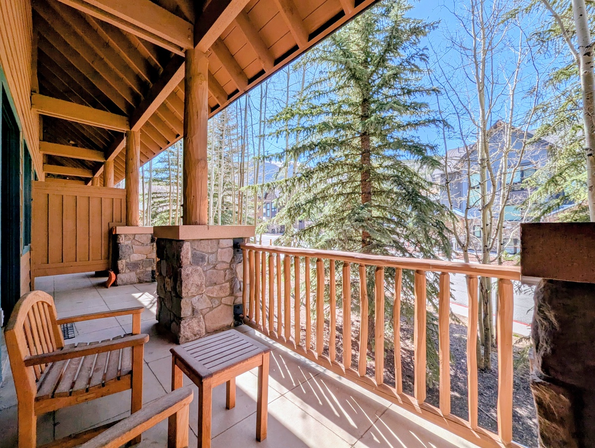 Sunlit mountain views framed by tall pines. Expansive decking blends rustic timber and stone accents beneath a soaring timber frame for peaceful afternoons outdoors.