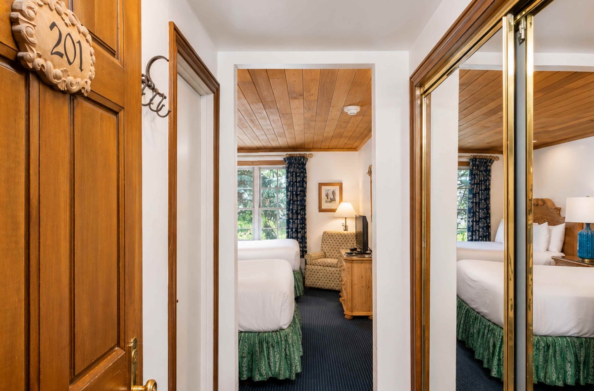 Step into your cozy retreat with warm wood tones and a plush bed ready to cradle you after a day of exploring. The peaceful room invites you to unwind in comfort and style.