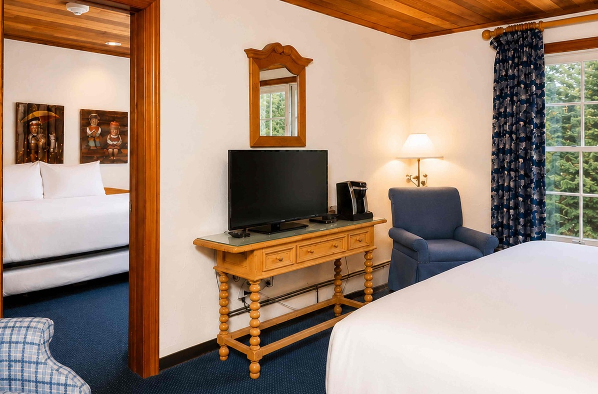 Relax in your spacious retreat with warm wood accents, charming décor, a flat-screen TV, and peaceful garden views framed by large windows.
