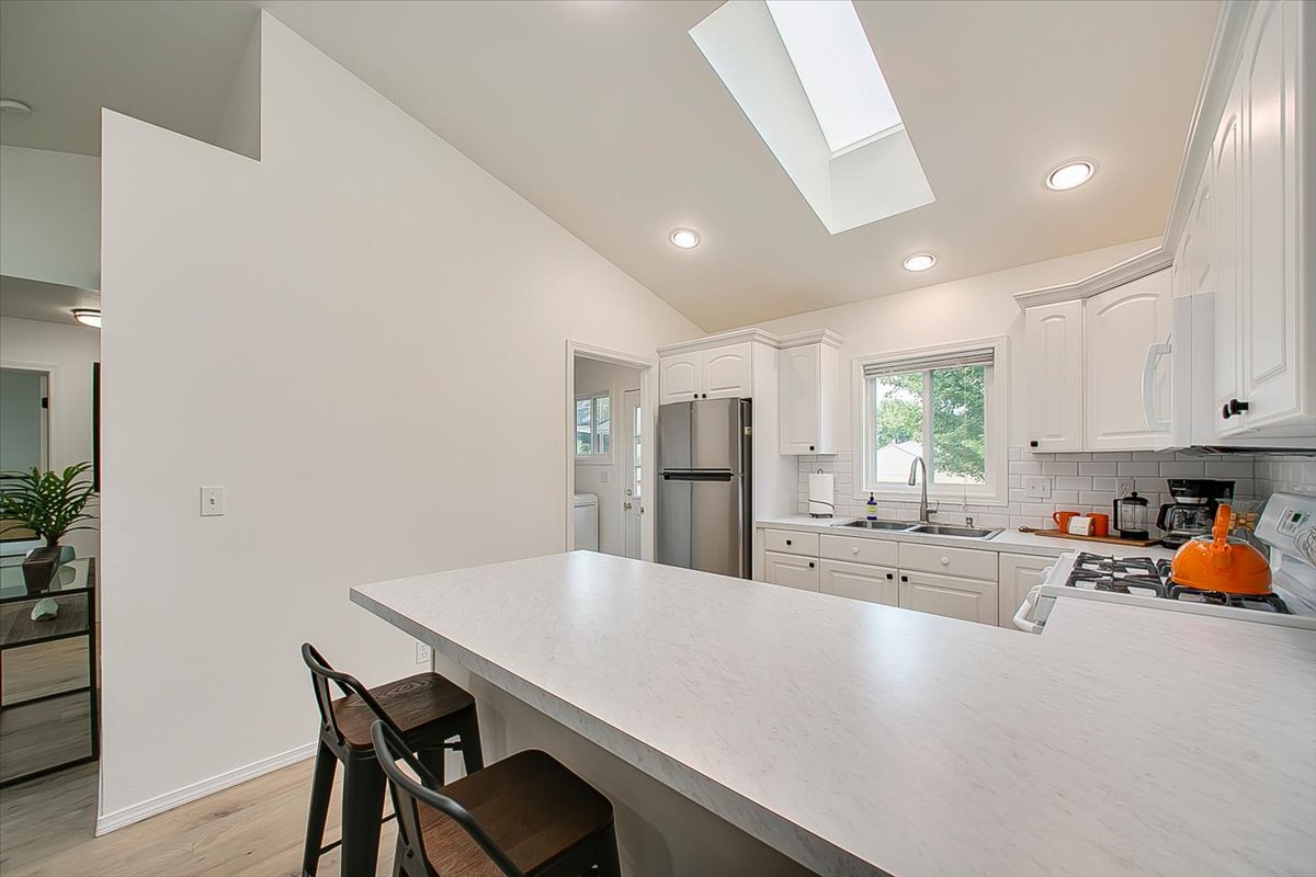 Your bright kitchen features white cabinets, modern appliances, and a skylight that floods the space with natural light for cooking adventures.