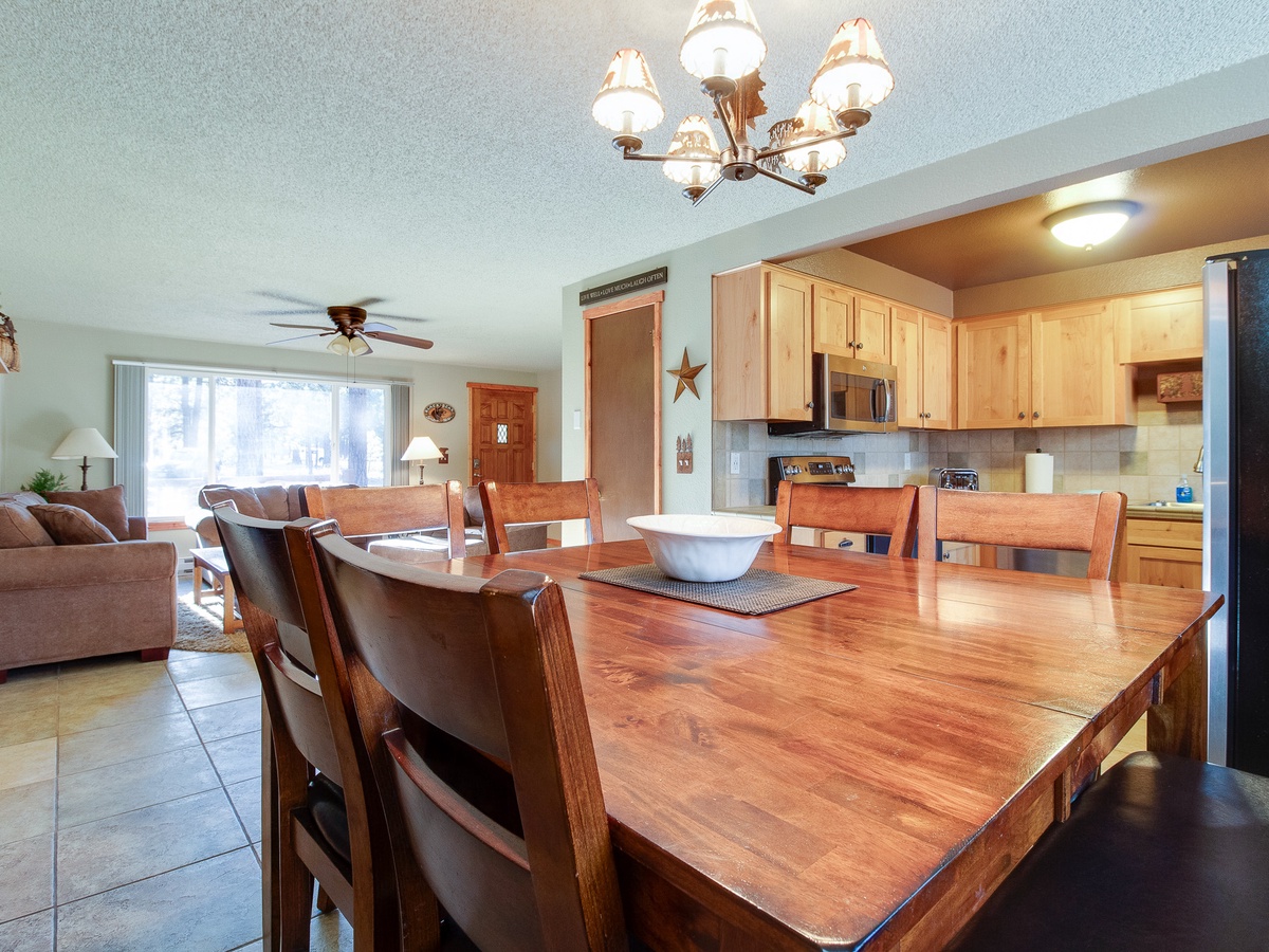 Gather around the warm wooden table where your group can share meals and stories. The open layout connects the fully-equipped kitchen with a cozy living area—perfect for relaxing together after a day of adventure.