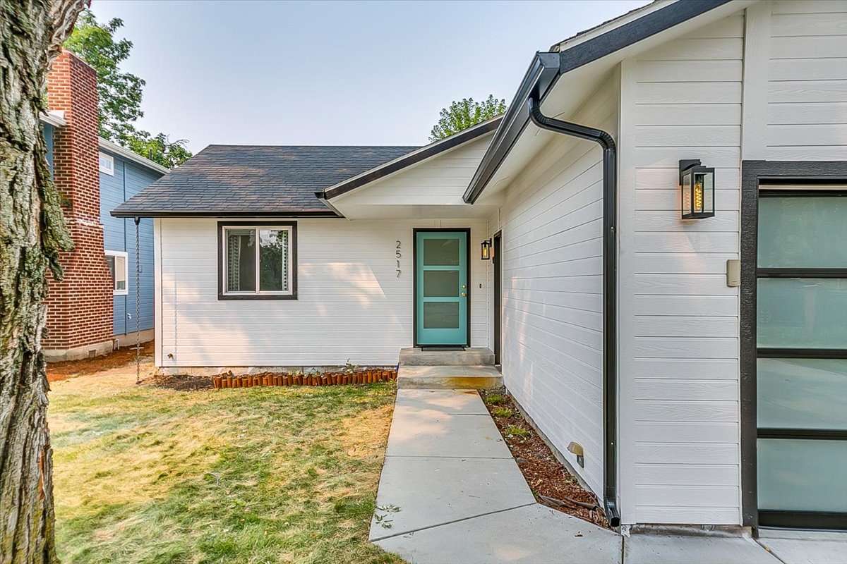 Modern home with stylish turquoise door and contemporary design in a quiet residential neighborhood.