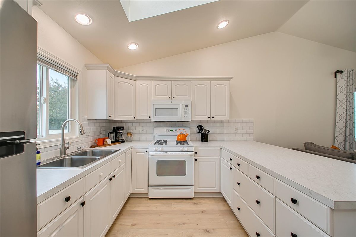 Your spacious kitchen features white cabinets, modern appliances, and plenty of counter space for preparing memorable meals during your stay.