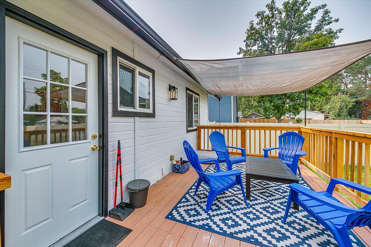 Your private deck features bright blue Adirondack chairs and a cozy sail shade, perfect for morning coffee or evening relaxation outdoors.