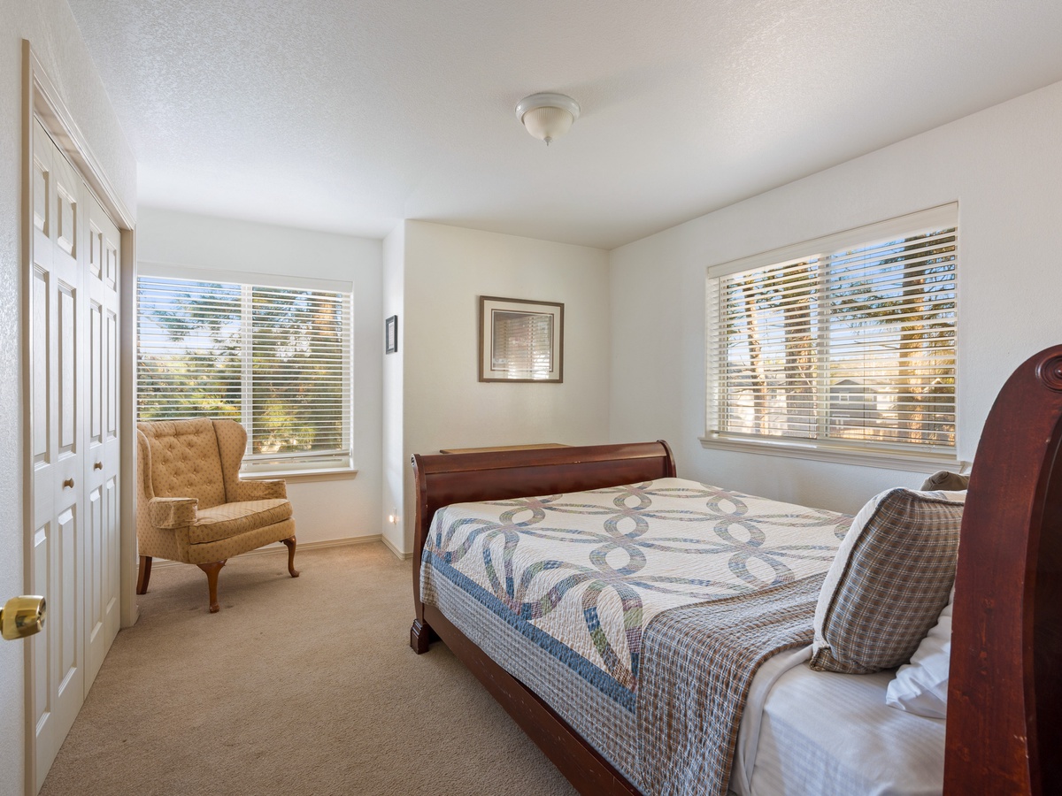 Unwind in your peaceful bedroom with natural light streaming through windows and a cozy reading chair for quiet moments.