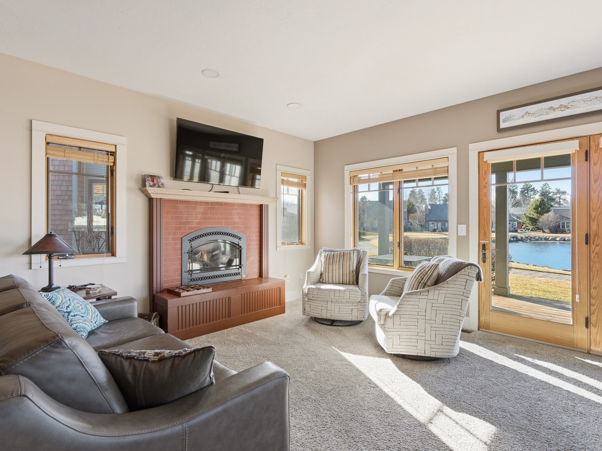 Unwind in your cozy living room with a crackling fireplace and stunning lake views streaming through floor-to-ceiling windows.