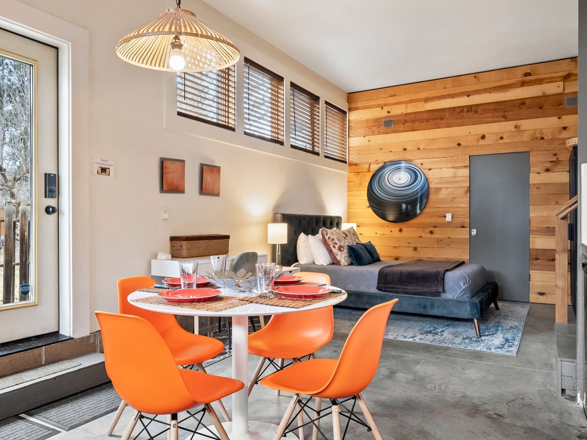 Step into your open-concept retreat where warm wood accents meet modern design. Natural light floods through high windows, illuminating your cozy living and dining spaces—perfect for relaxing evenings or memorable meals together.