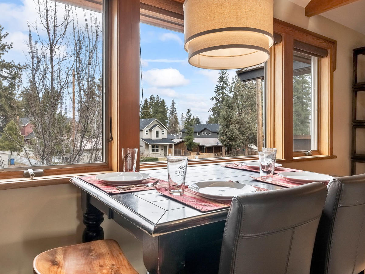 Enjoy your morning coffee at this cozy dining nook, where charming mountain-town views through expansive windows make every meal feel special.