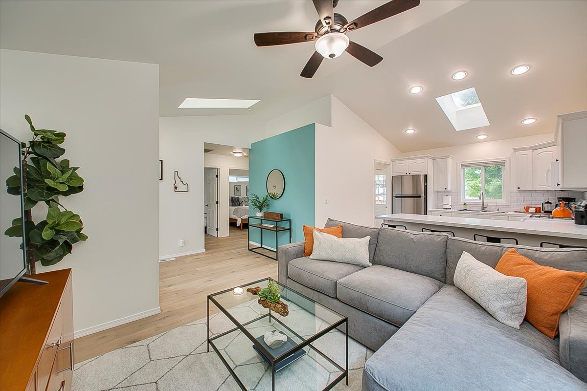 Relax on your spacious sectional sofa in this bright, modern living space featuring vaulted ceilings and an open layout connecting to your fully equipped kitchen.