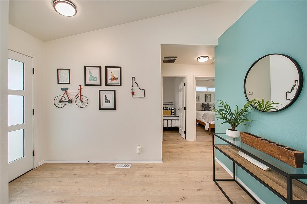 Step into this bright, welcoming space where modern style meets comfort. The soothing mint accent wall and warm wood floors create your perfect home base.