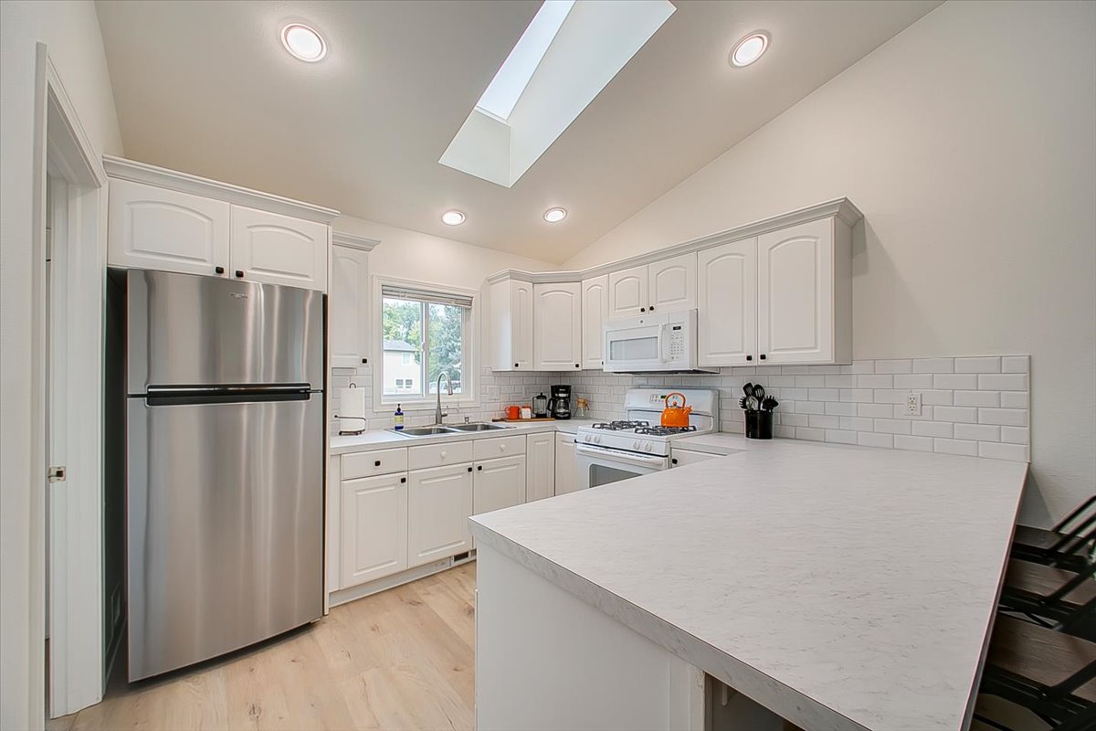 Your bright, modern kitchen features sleek white cabinets, stainless steel appliances, and a spacious island perfect for cooking memorable meals together.