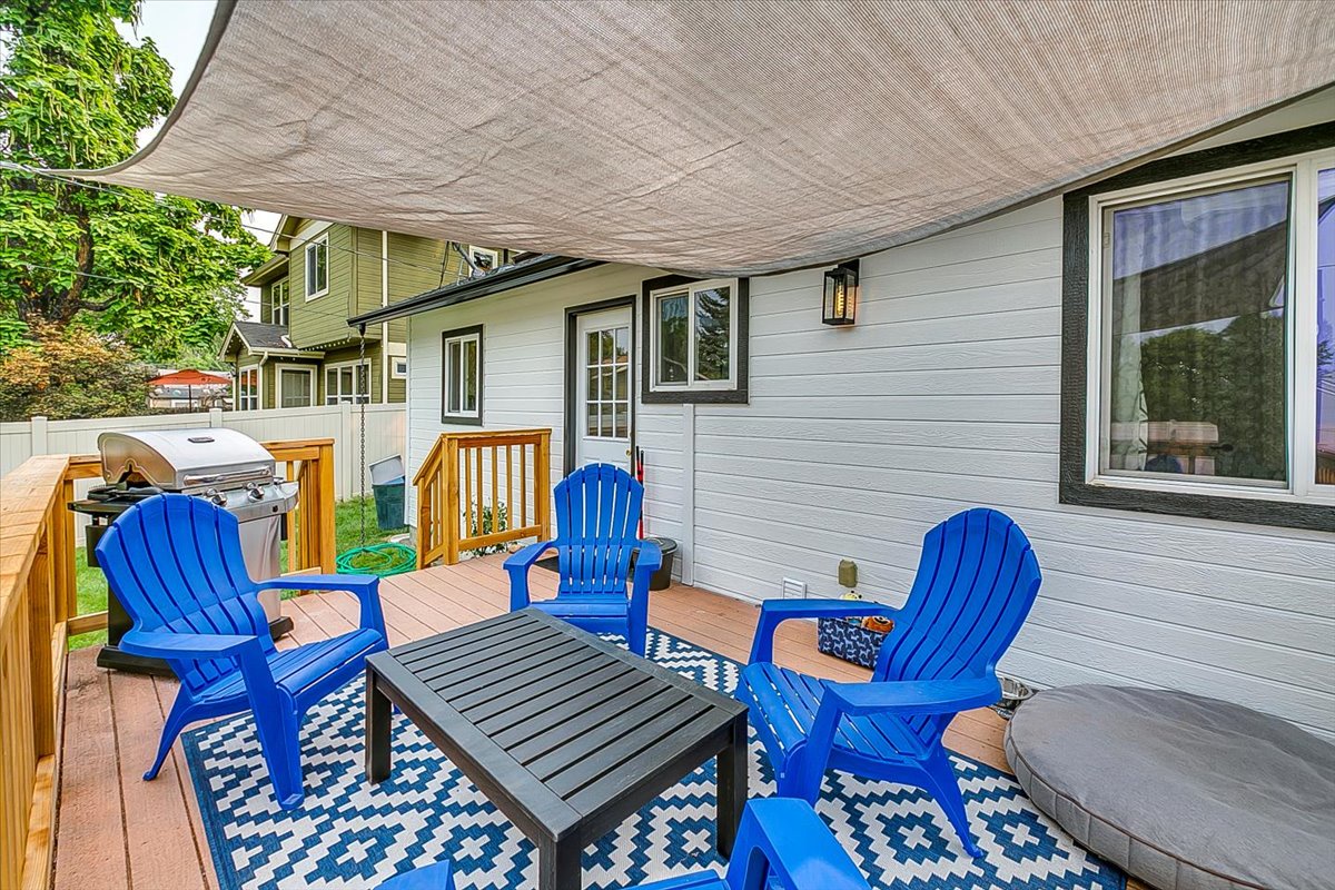 Unwind on your private covered deck with vibrant blue Adirondack chairs and a cozy outdoor dining setup, perfect for morning coffee or evening relaxation.