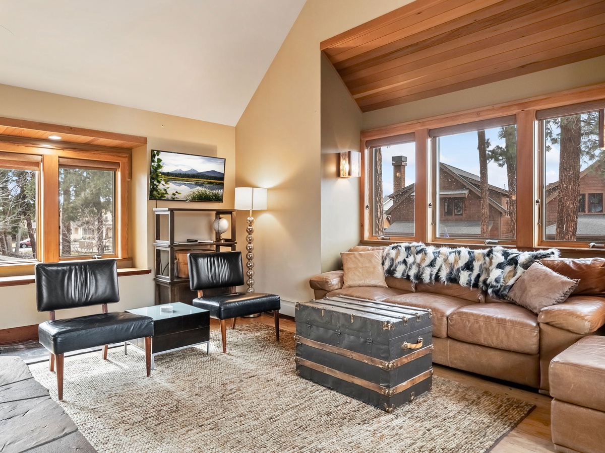 Sink into plush leather seating in your airy living room, where exposed wood beams frame alpine views and a vintage trunk doubles as your coffee table.