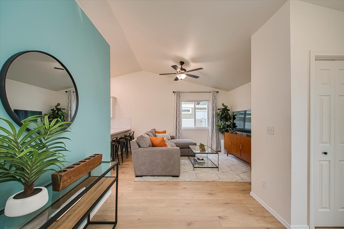 Step into your stylish open living space where modern comfort meets coastal charm, complete with cozy seating and vibrant accents.